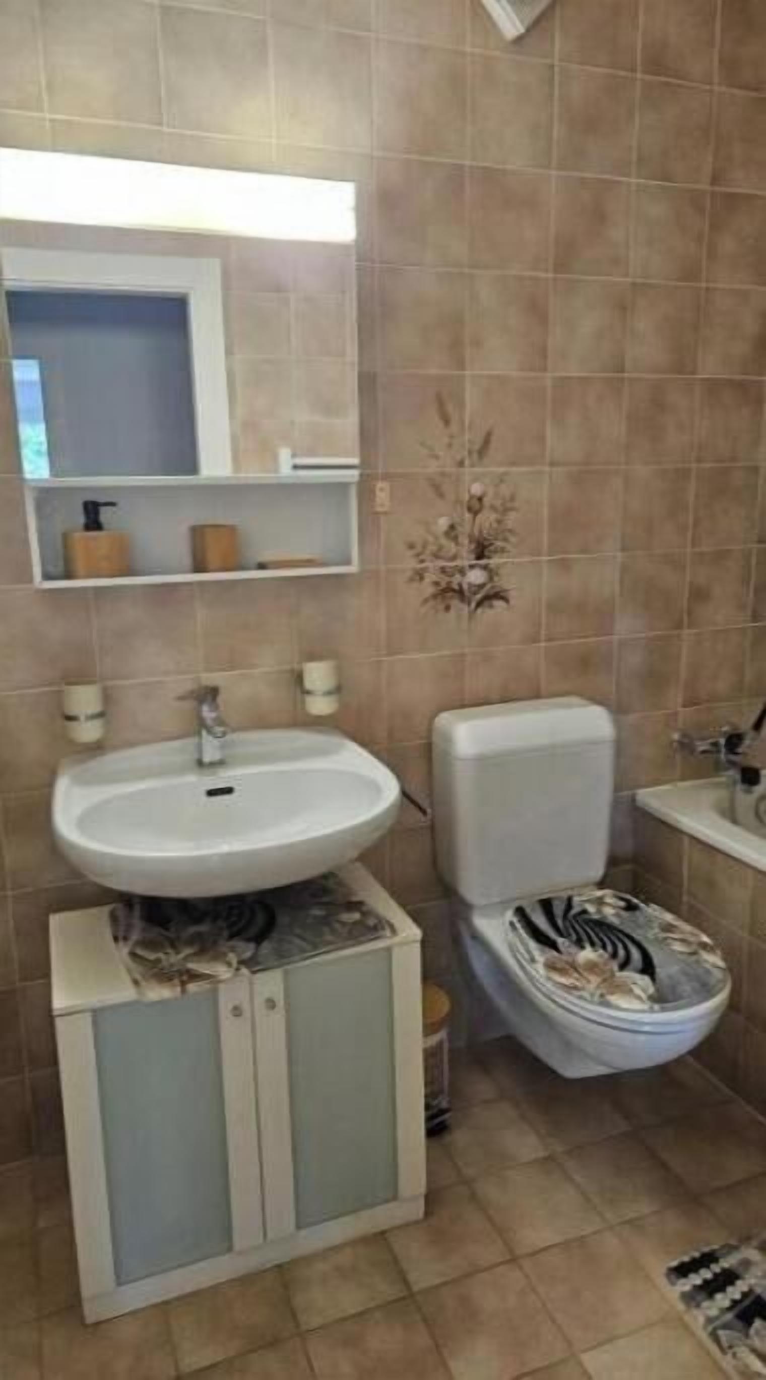 Une salle de bain avec un lavabo, des toilettes et un miroir.