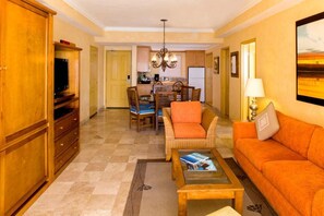 A living room with a sofa, coffee table, and a dining area with chairs and a table. - LUXURY 2BR Villa Del Arco Oceanfront 5 STAR Resort - Medano Beach DEC 19-26 (Cabo San Lucas)