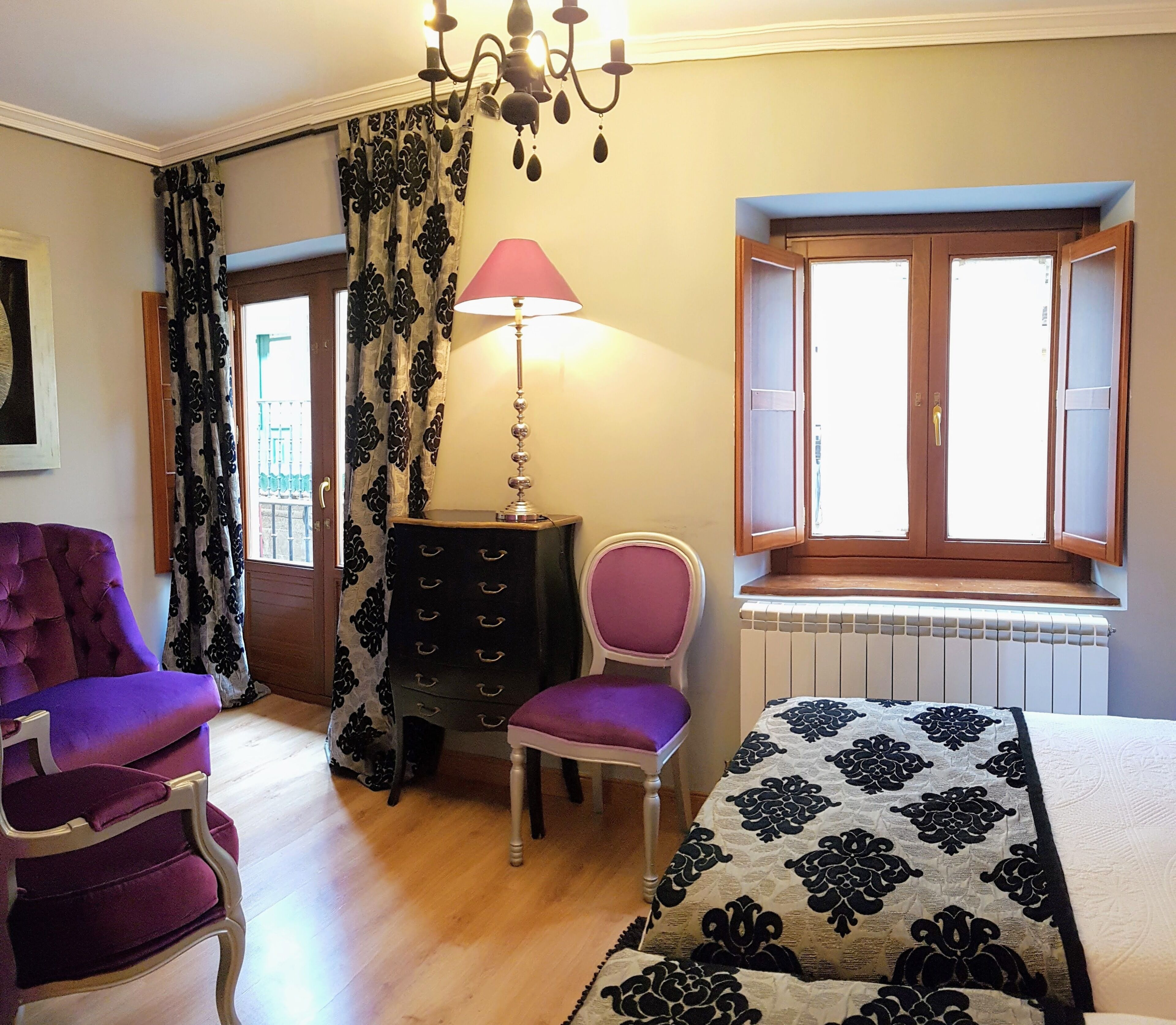 Une pièce comprenant un lit, une commode, une chaise, une lampe et une fenêtre.