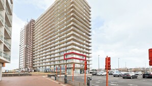 Een meerhoog gebouw met een modern architectuurontwerp, voorzien van een reeks balkons en grote ramen.