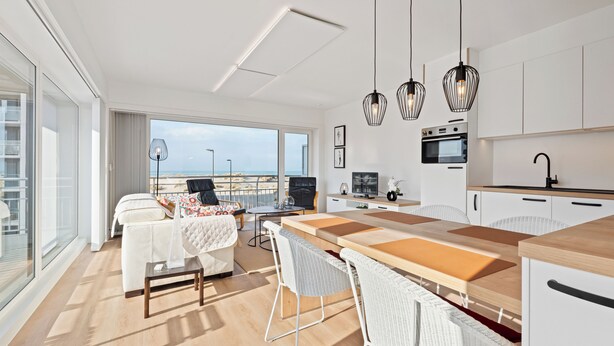 Een moderne keuken met een houten kookeiland, witte kastjes en hanglampen.