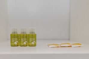 Drei Flaschen Haar- und Duschgel stehen auf einem weißen Regal.