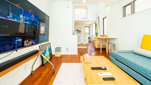 Un salon moderne avec un téléviseur à écran plat, une table basse en bois et un canapé de couleur turquoise.