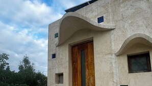 Ein Gebäude mit einem markanten architektonischen Design, mit einer Holztür und kleinen Fenstern.