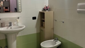 Un baño con lavamanos, bidé y retrete.