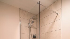 Un bagno moderno con doccia vetrata, un water e un bidet.