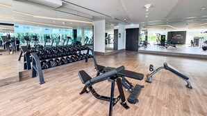 A modern gym with exercise equipment, mirrored walls, and a wooden floor. - PVH - Opalz by Danube 1BR with Jacuzzi (Dubai)