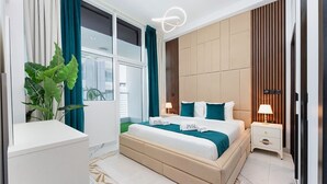 A modern bedroom with a large bed, bedside tables, a potted plant, and a view of the city through large windows. - PVH - Opalz by Danube 1BR with Jacuzzi (Dubai)