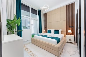 Een moderne slaapkamer met een groot bed, nachtkastjes, een kamerplant en uitzicht op de stad door grote ramen.