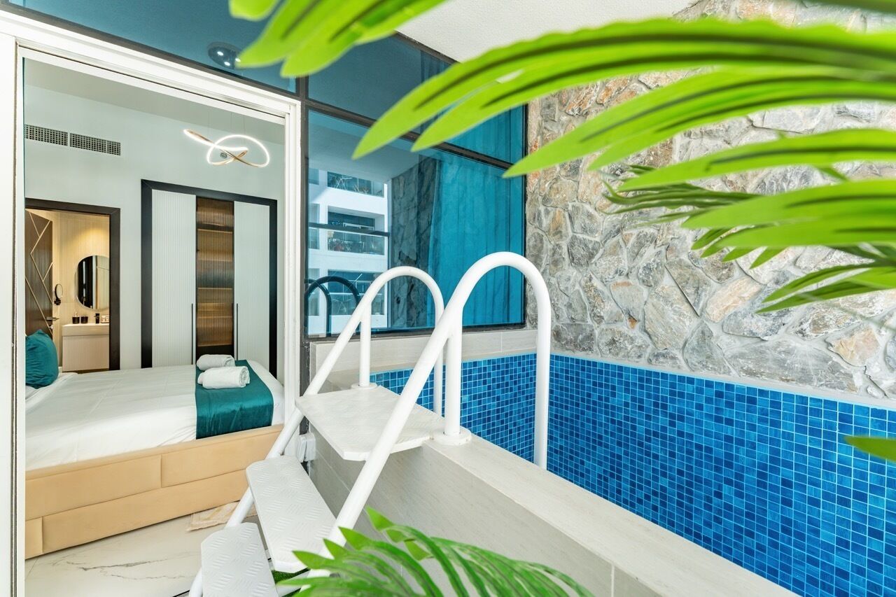 Une salle de bain moderne avec une douche à l’italienne, une baignoire blanche et un mur en pierre.