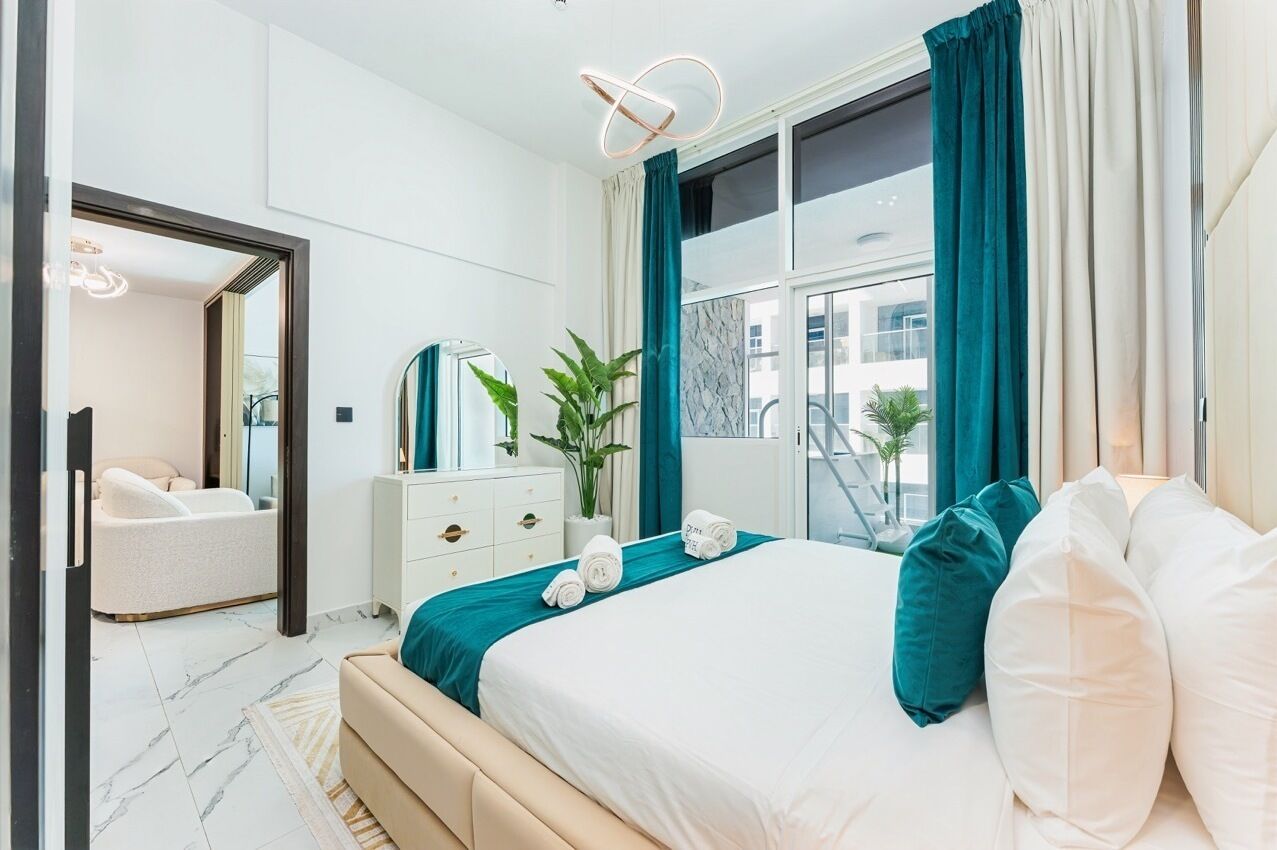 Een moderne slaapkamer met een groot bed, een nachtkastje, een spiegel en uitzicht op de stad.