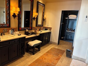 Un bagno con due lavandini, uno specchio grande e una panca.