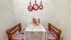 A dining area with a table set for two, a bowl of fruit, and a board game. - Apto Maison | 5-minute walk from Central Park (Antigua Guatemala)