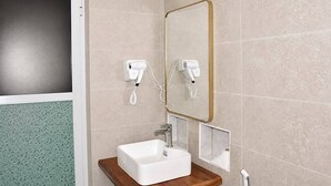 A bathroom with a white sink, a mirror with a gold frame, and two hair dryers mounted on the wall. - The Lagoons Turtle Resort (Nungwi)