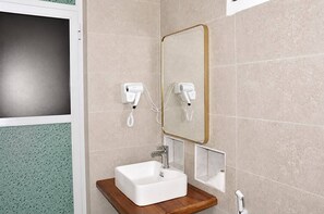 A bathroom with a white sink, a mirror with a gold frame, and two hair dryers mounted on the wall. - The Lagoons Turtle Resort (Nungwi)