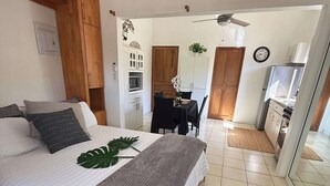 Ein Schlafzimmer mit Bett, einer Essecke und einer Küchenzeile.