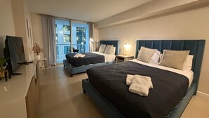Une chambre d’hôtel avec deux lits, une télévision, un bureau et un balcon avec vue.