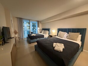 A hotel room with two beds, a TV, a desk, and a balcony with a view. - Brickell Studio | Free Parking | Skyline View (Brickell)