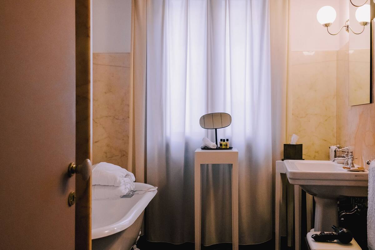 Une salle de bain avec une baignoire, un lavabo et un miroir.