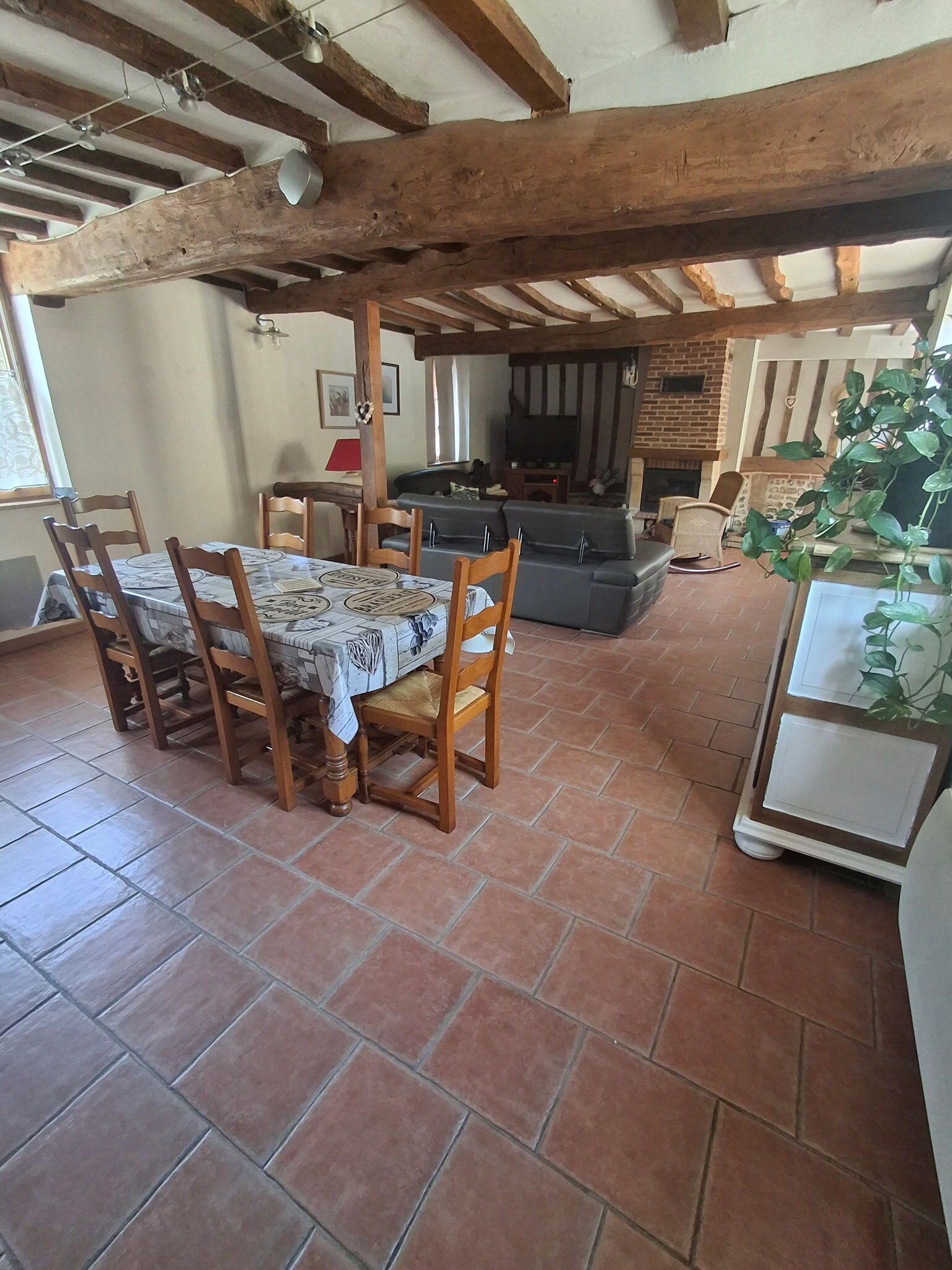 Un comedor con mesa y sillas, un sofá, un televisor y una chimenea.