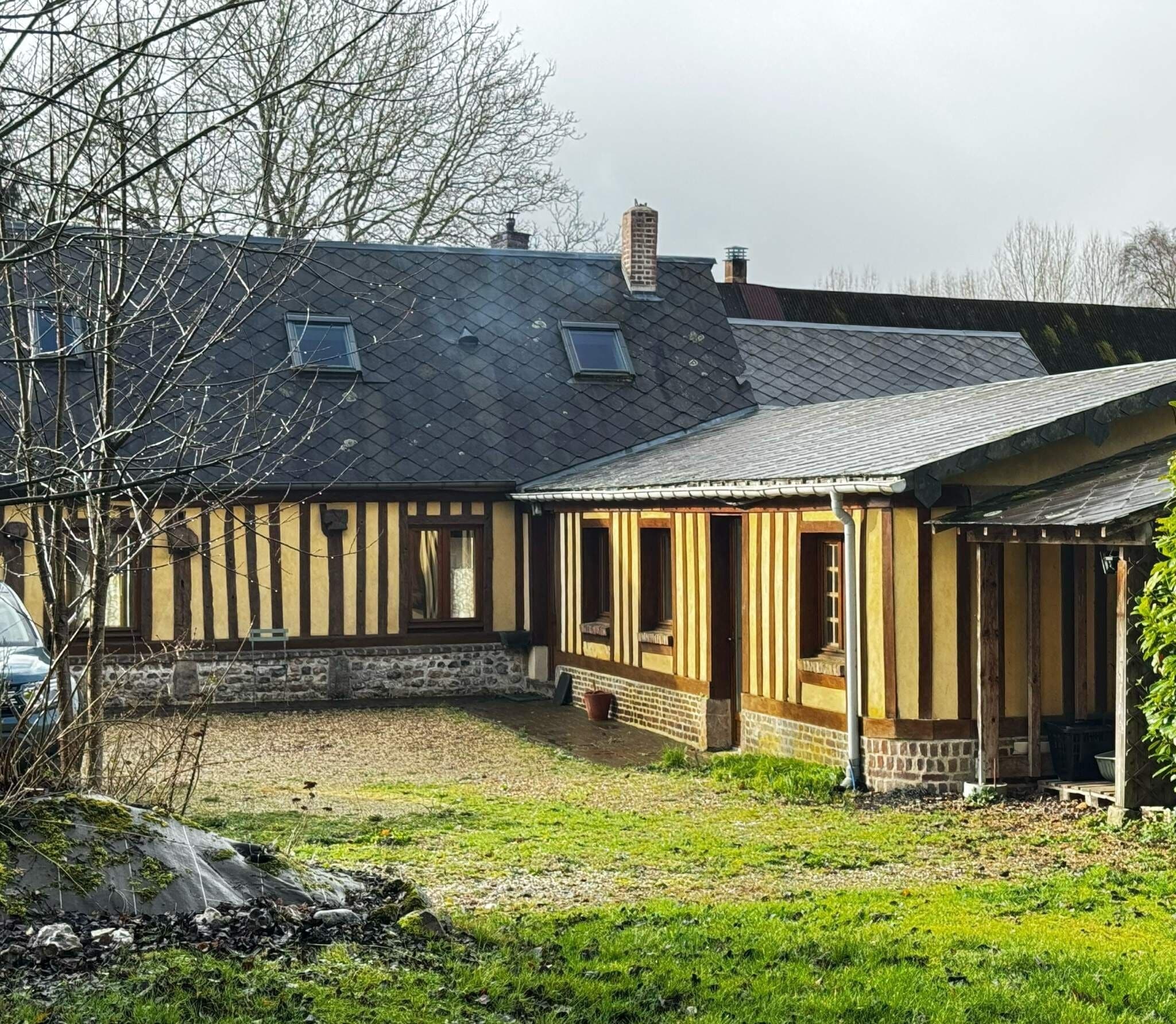 A traditional building with a stone foundation, a sloped roof, and a wooden porch.