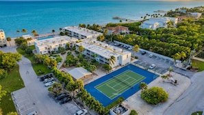 A residential area with a tennis court, parking, and a view of the ocean. - Keys Coastal Escape Pool Beach Ocean U20 (Marathon)