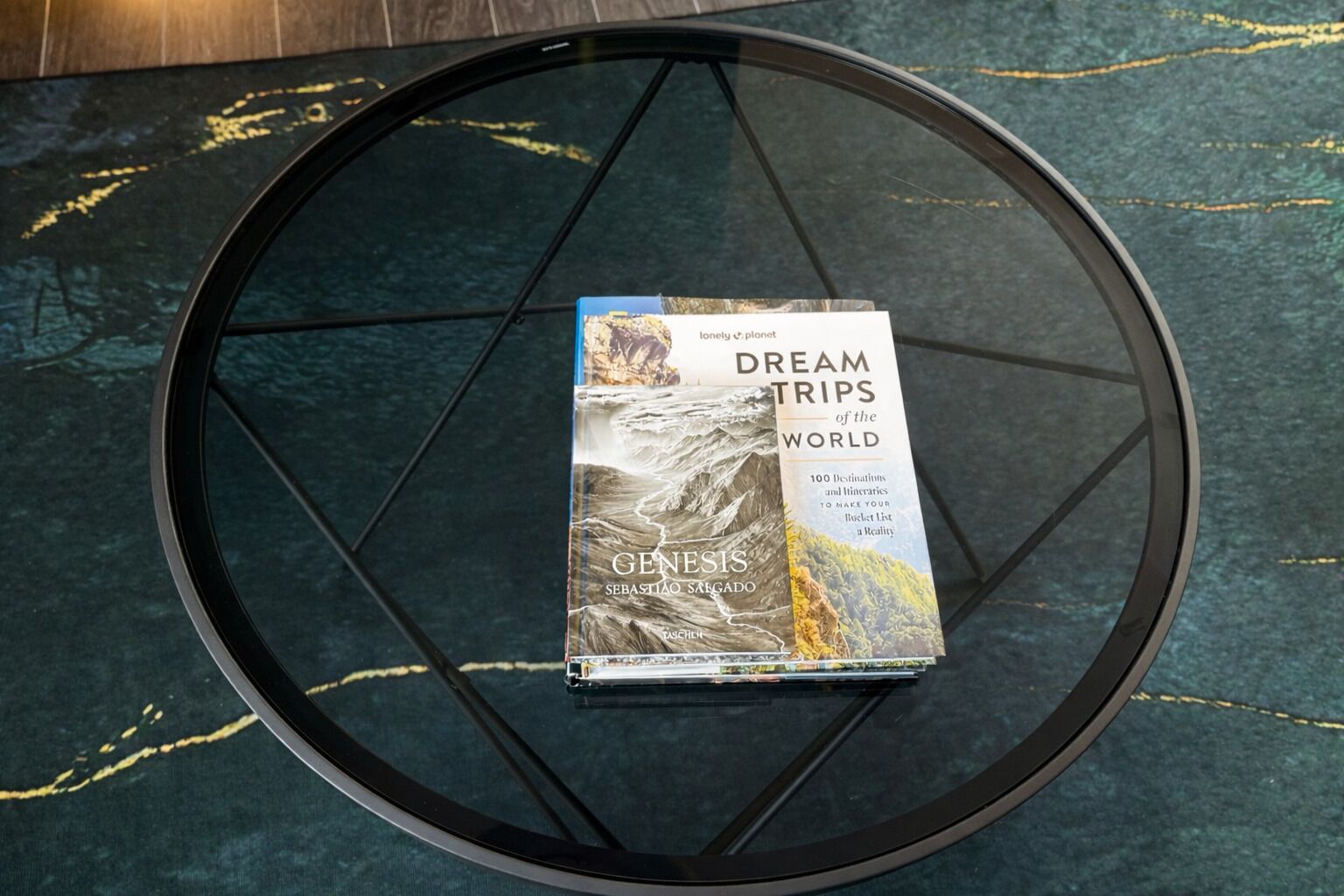 Ein Buch mit dem Titel 'Dream Trips of the World' von Genesis Sebastiano Seregado auf einer Glastisch.