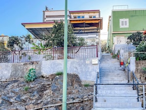 A residential building with a staircase leading to a gated entrance. - Lovely Apartment in Beautiful Mogan (Los Pasitos)