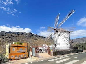 A windmill, a museum, and a building with a sign. - Lovely Apartment in Beautiful Mogan (Los Pasitos)