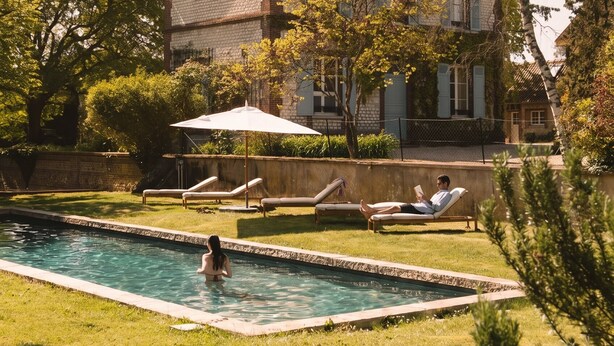 A house with a swimming pool, lounge chairs, and a tree. - RIVE Side House    . (Muids)