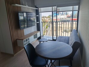 A balcony with a sofa, a dining table, and chairs. - Dpto en Santa Catalina, Cerca a Centro Financiero (Lima)
