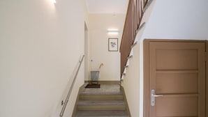 A narrow staircase with handrails, a door at the bottom, and a small framed picture on the wall. - Central Cernobbio - Modern Apartment (Cernobbio)
