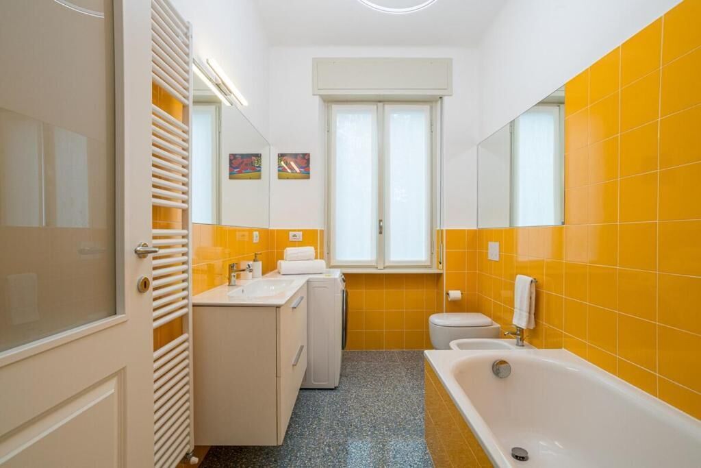 Ein Badezimmer mit einer weißen Badewanne, einer Toilette und einem Waschbecken.