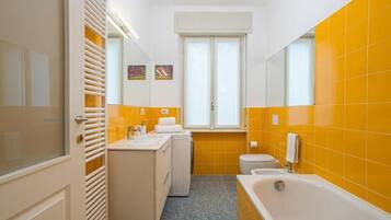 Ein Badezimmer mit einer weißen Badewanne, einer Toilette und einem Waschbecken.