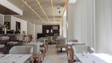 Un restaurant moderne doté d’un long comptoir, de nombreuses tables et de chaises.