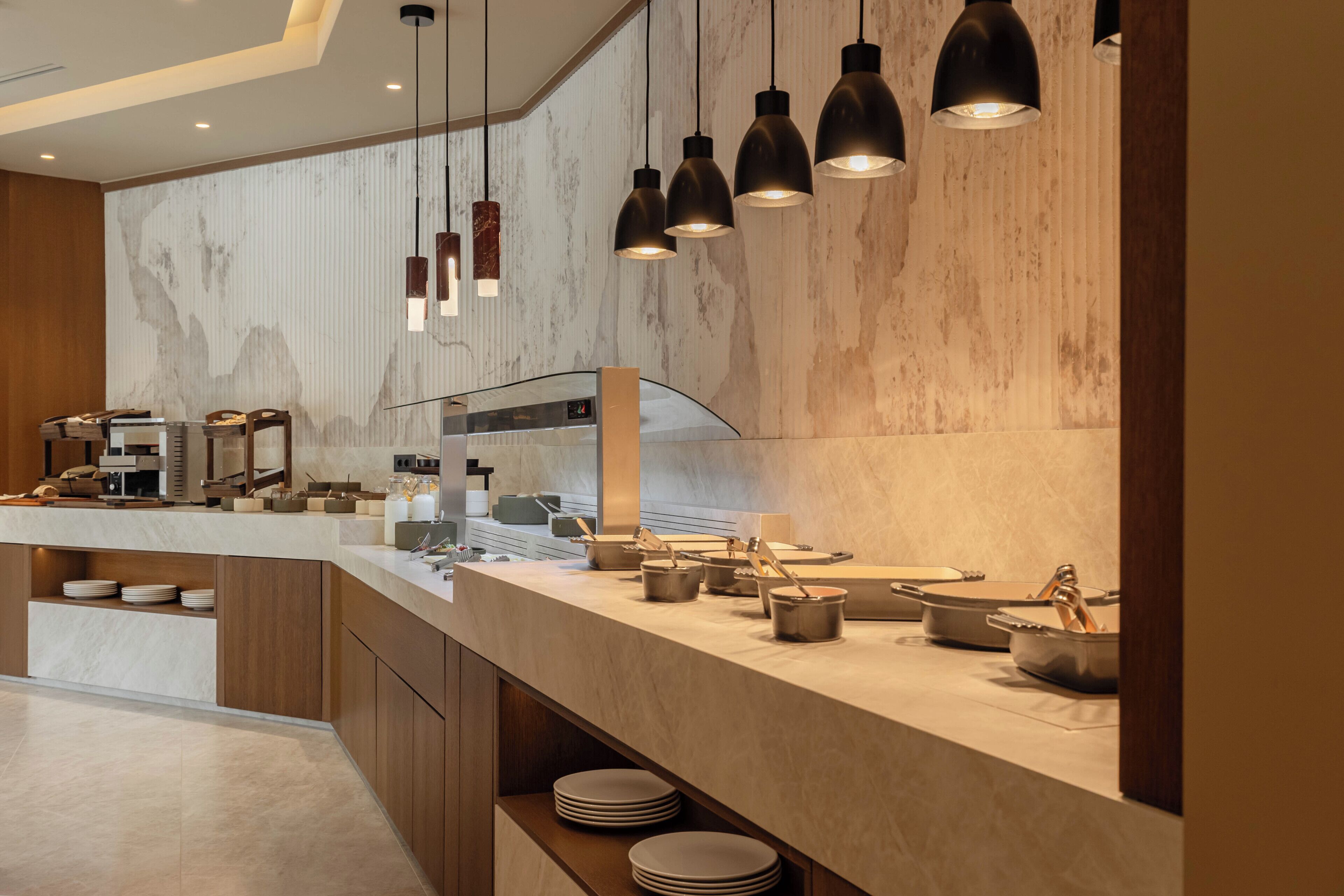 A modern kitchen with a marble backsplash, pendant lighting, and a variety of kitchenware.