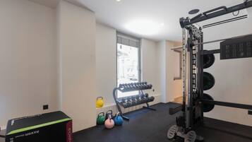 Ein Fitnessraum mit Hantelgestell, Kettlebells und Kurzhanteln.