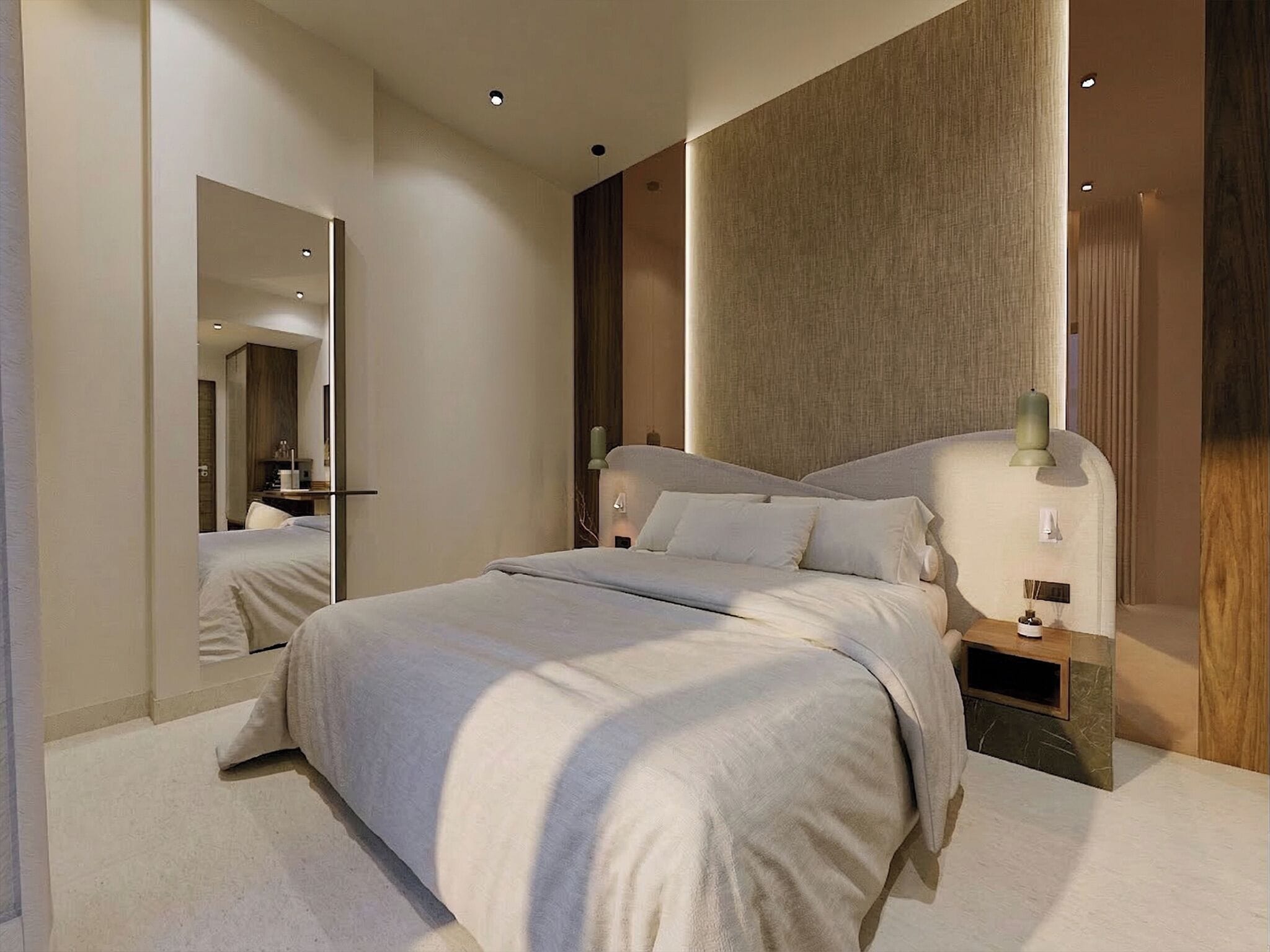 Quarto de hotel moderno com uma cama grande, uma mesa de cabeceira, um espelho e uma luminária fixada na parede.
