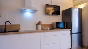 Eine moderne Küche mit einem Edelstahl-Kühlschrank, einer Mikrowelle und einem Einbauofen.