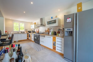 A modern kitchen with white cabinets, a stainless steel refrigerator, and a microwave. - Villa with pool 2.5km from Saint-Tropez (Gassin)