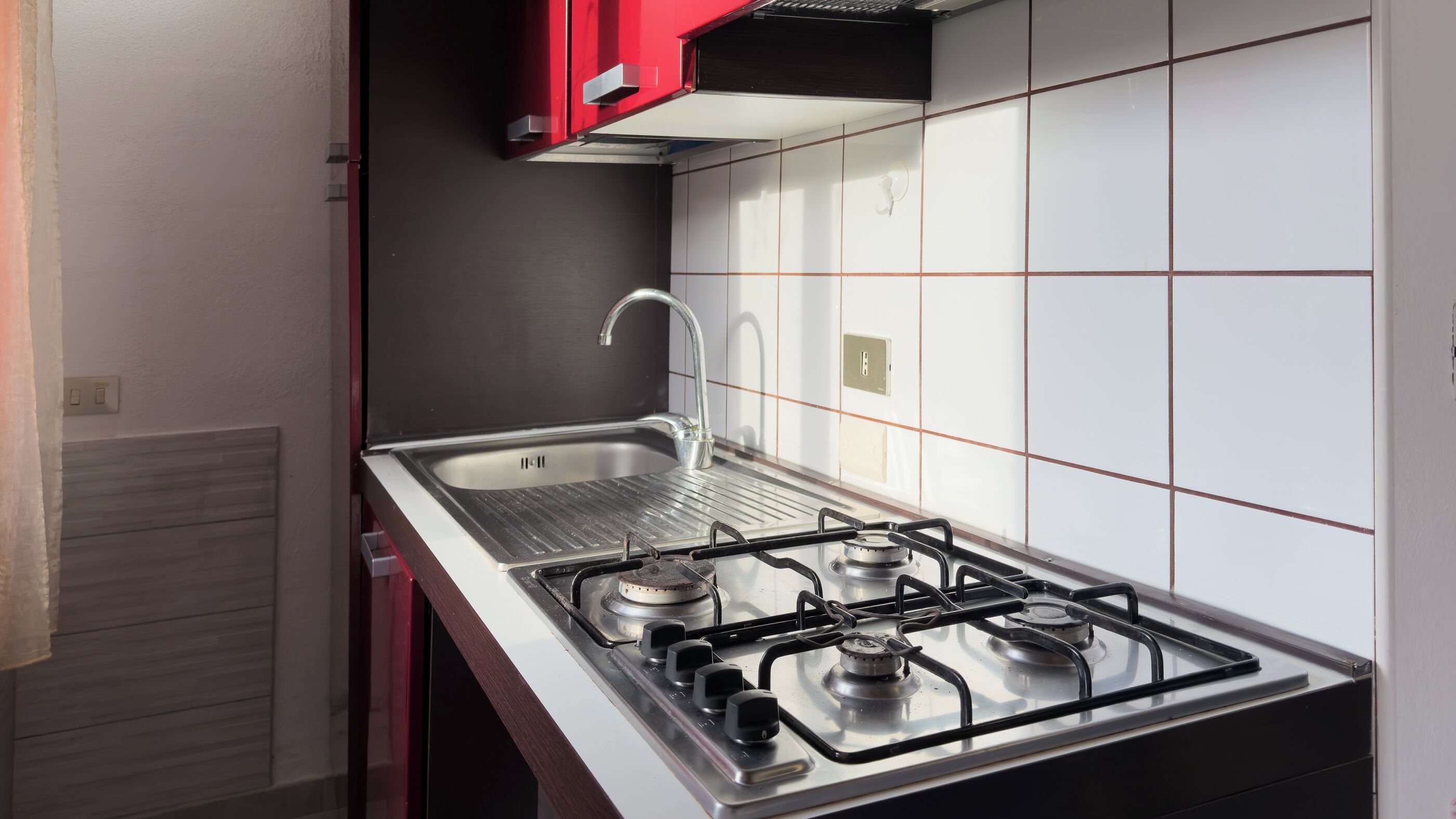 Een oven, een kookplaat, kookgerei, borden en bestek, een eettafel