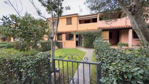 A residential building with a paved driveway, a well-maintained lawn, and a metal gate. - Residenze Cielo e Mare - Conchiglia (San Teodoro)