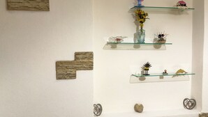 A wall with three glass shelves displaying various decorative items. - Residenze Cielo e Mare - Conchiglia (San Teodoro)