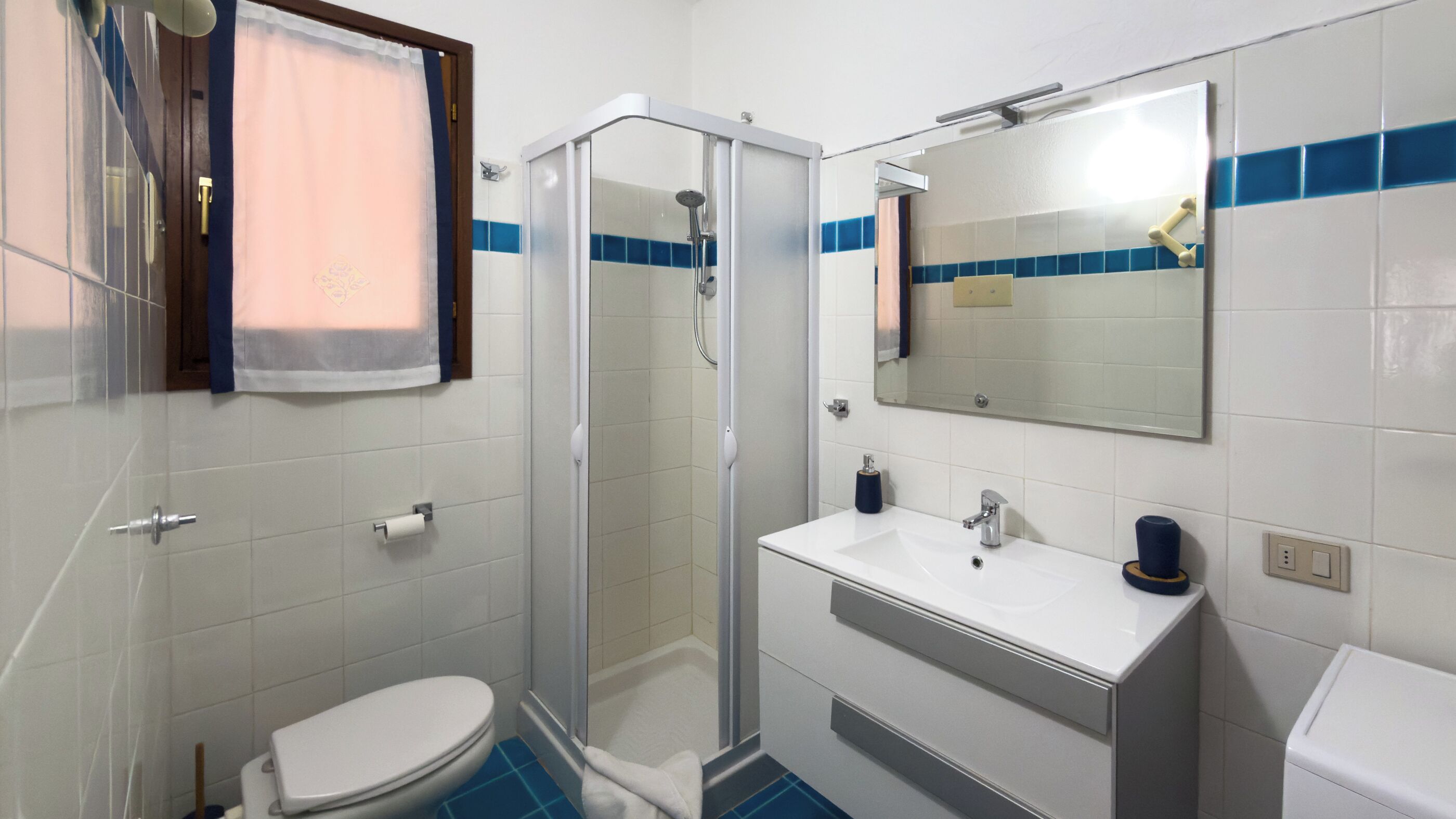Une salle de bain avec des toilettes, une douche et un lavabo.