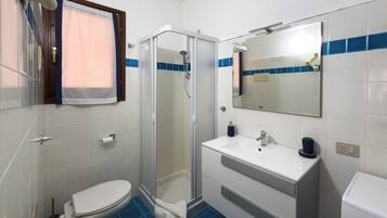 Une salle de bain avec des toilettes, une douche et un lavabo.