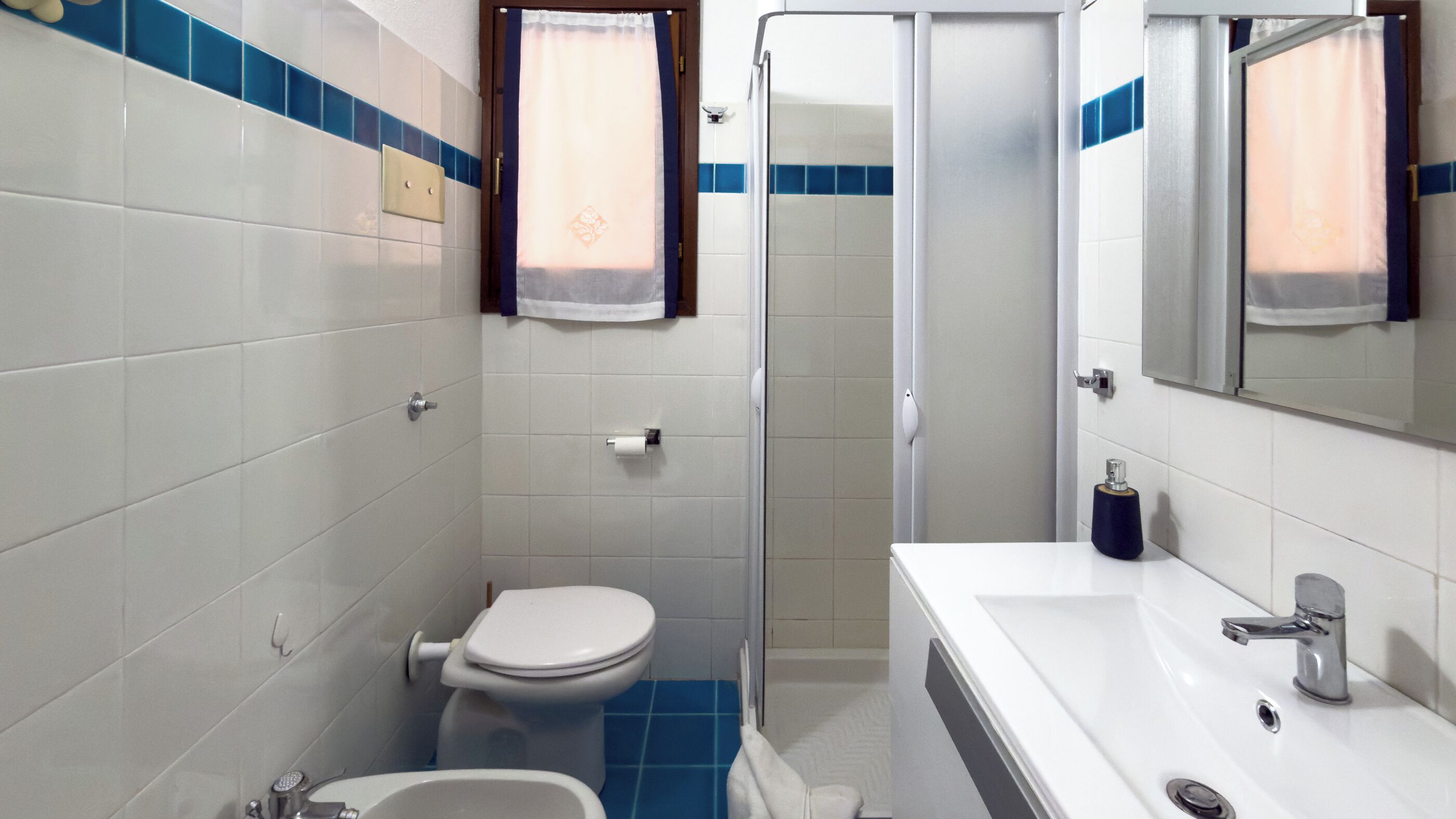 Ein Badezimmer mit Toilette, Waschbecken und Dusche.