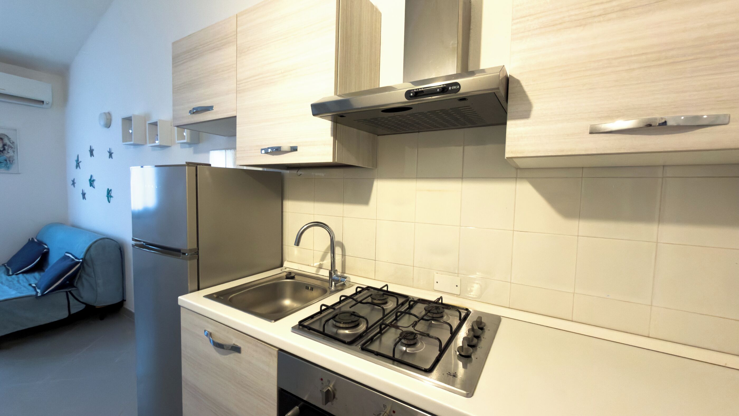 Een koffiezetapparaat/waterkoker, een koelkast, een oven, een kookplaat