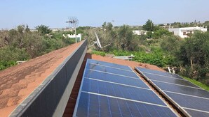 Un toit équipé de panneaux solaires et d’une antenne parabolique.