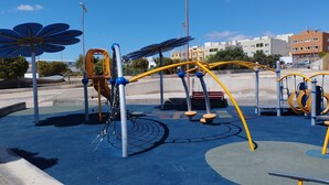 Un’area giochi con diverse strutture, tra cui altalene, scivoli e elementi per arrampicata.