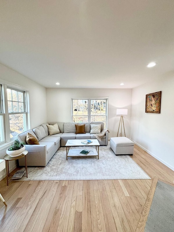 A modern living room with a sectional sofa, a coffee table, and a floor lamp.